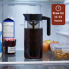 One glass Cold Brew Maker with a black plastic lid and handle inside a refrigerator. Text: Brew for 12-24 hours.