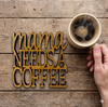 laser cut wooden coaster 'Mama needs a coffee' on a table with a person holding a cup of coffee