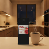 Straightened Decaf Colombia coffee bag beside a steaming mug in a warmly lit kitchen at night